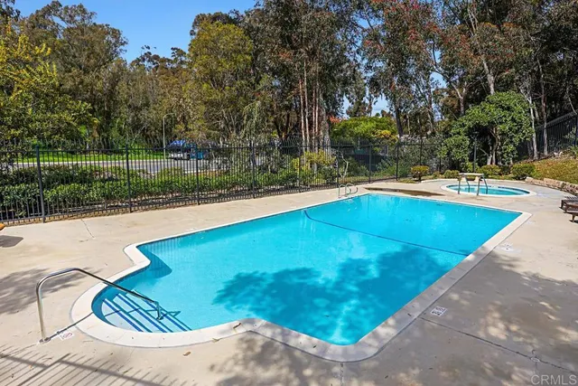 a view of a backyard with swimming pool and sitting area