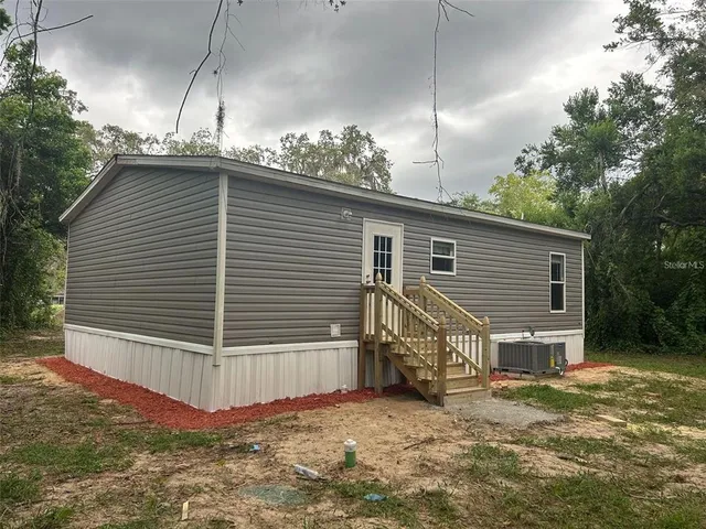 a view of house with backyard and trees