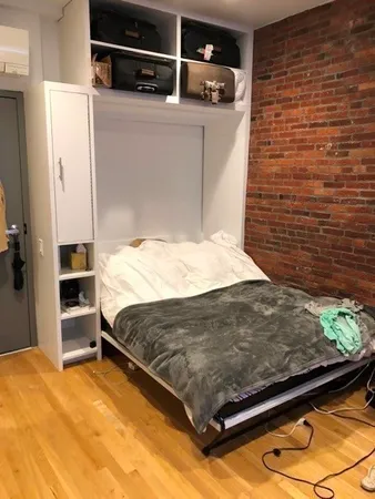 a bed sitting in a bedroom next to a bathroom