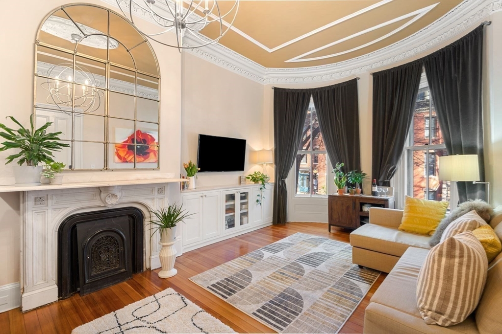 232 West Canton Street, Unit 2 Boston, MA 02116 - Photo 2 of 23 a living room with furniture a flat screen tv and a fireplace