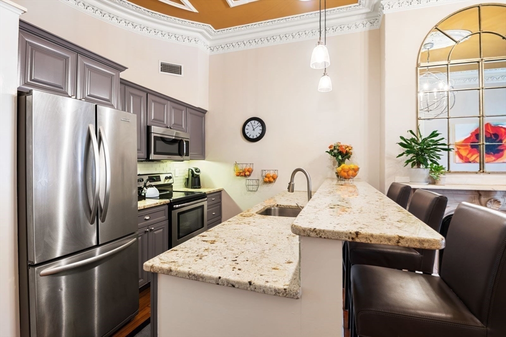 232 West Canton Street, Unit 2 Boston, MA 02116 - Photo 6 of 23 a kitchen with stainless steel appliances granite countertop a refrigerator sink and stove