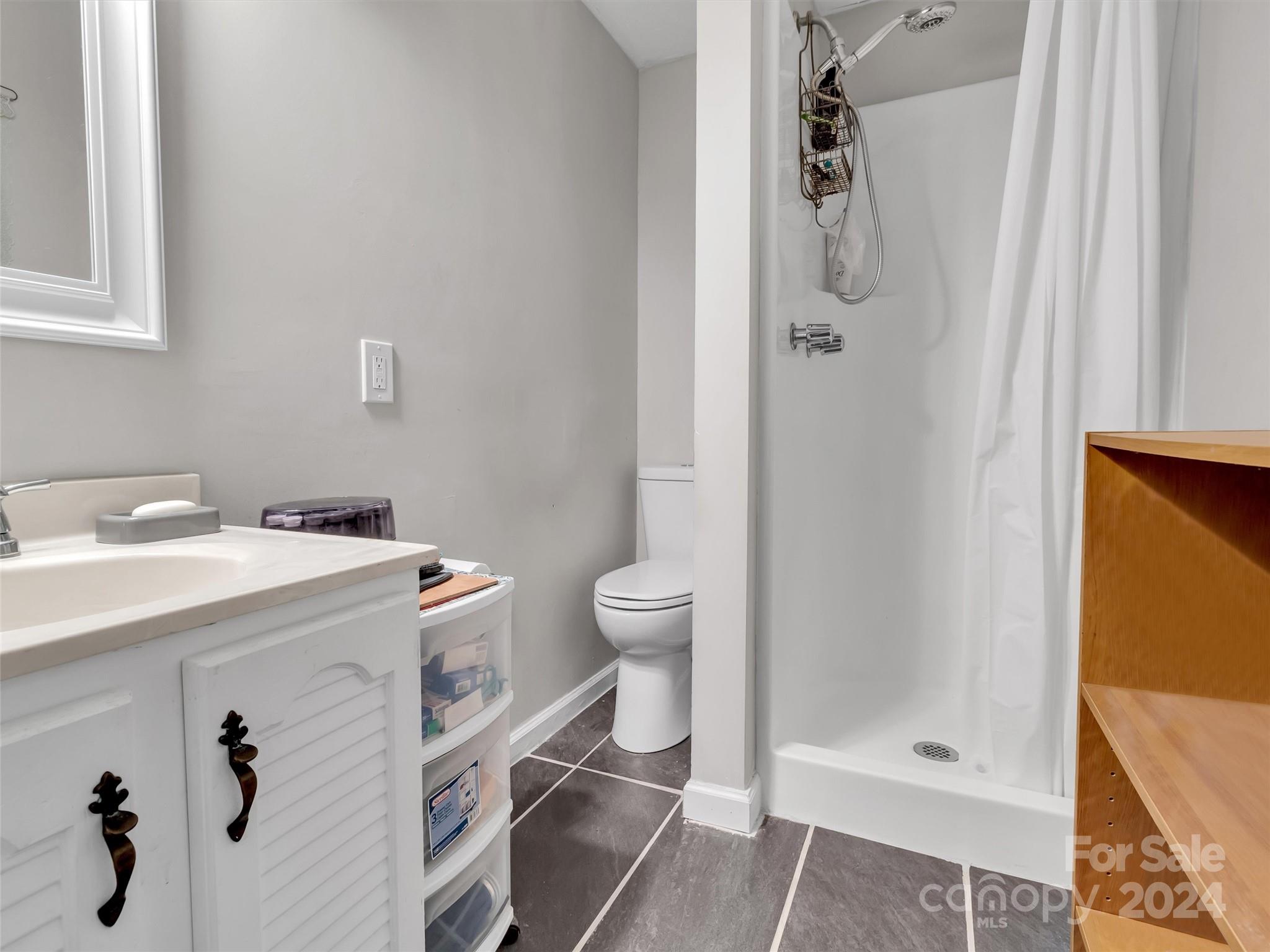 197 Mulberry Street Clyde, NC 28721 - Photo 20 of 20 a bathroom with a sink a toilet and shower