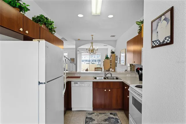 a kitchen with stainless steel appliances granite countertop a refrigerator a sink dishwasher a stove and a refrigerator