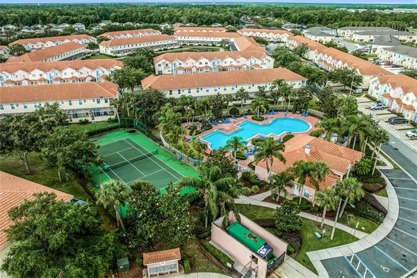 an aerial view of residential houses with outdoor space and trees