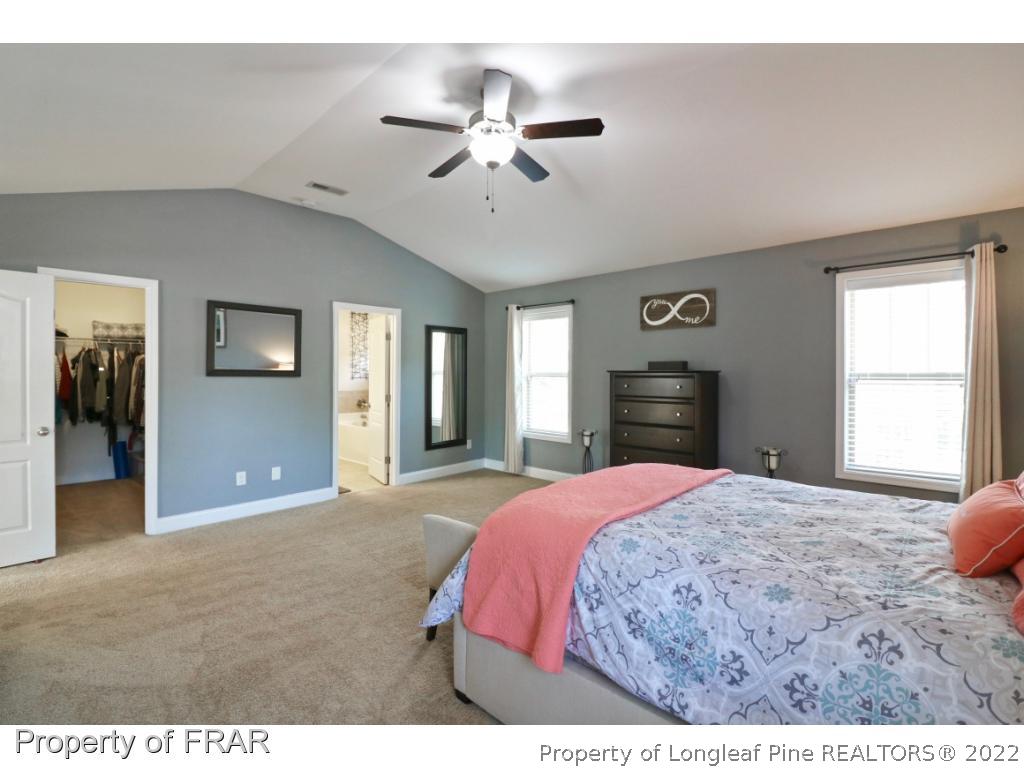 740 Sun Road Aberdeen, NC 28315 - Photo 19 of 36 a bedroom with a large bed and a chandelier