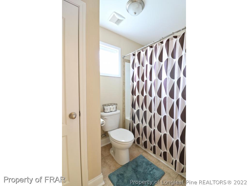740 Sun Road Aberdeen, NC 28315 - Photo 25 of 36 a bathroom with a toilet and a shower curtain