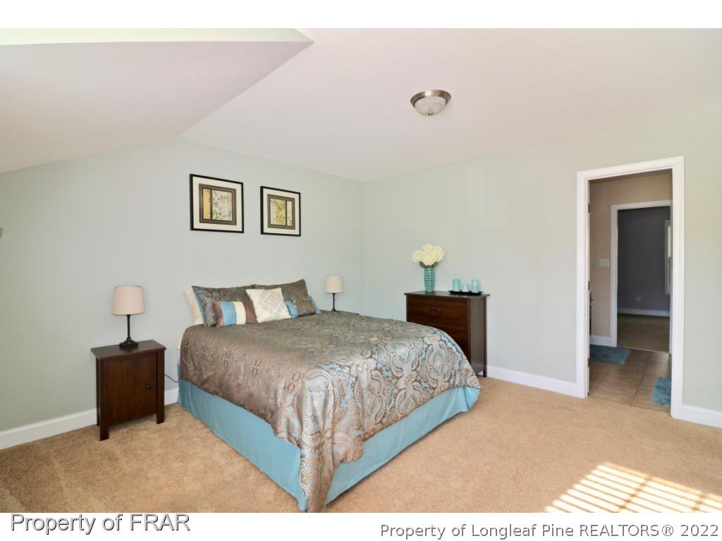 740 Sun Road Aberdeen, NC 28315 - Photo 27 of 36 a bedroom with a bed and a painting on the wall