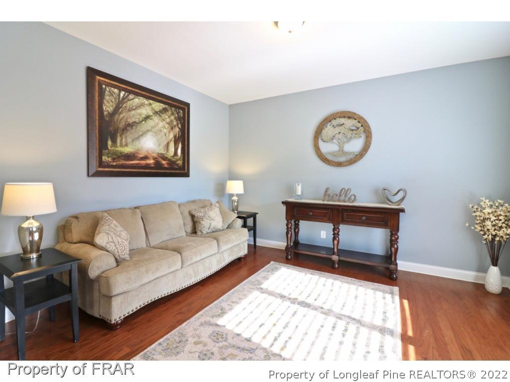 740 Sun Road Aberdeen, NC 28315 - Photo 3 of 36 a living room with furniture a clock on wall and a table