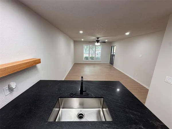 a kitchen with granite countertop a sink and a refrigerator