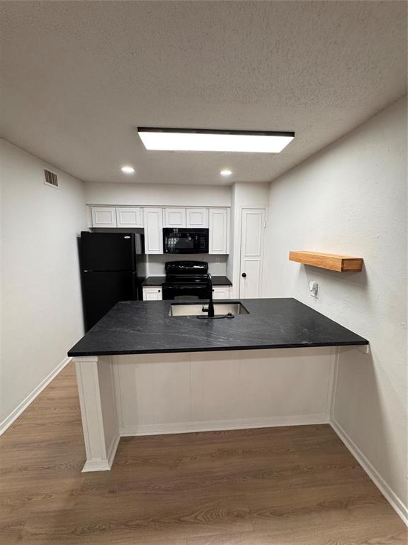 4859 Cedar Springs Road, Unit 150 Dallas, TX 75219 - Photo 21 of 24 a view of kitchen island with stainless steel appliances granite countertop refrigerator sink and wooden floor