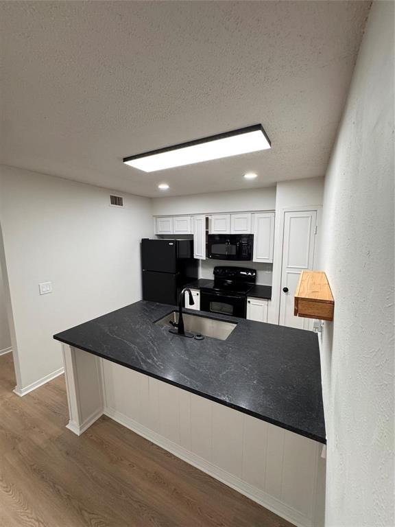 4859 Cedar Springs Road, Unit 150 Dallas, TX 75219 - Photo 10 of 24 a kitchen with kitchen island a sink a stove and a refrigerator