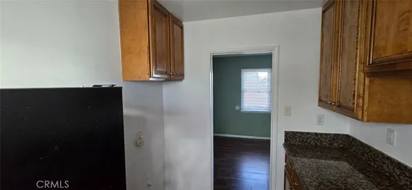 a view of hallway with wooden floor and cabinets