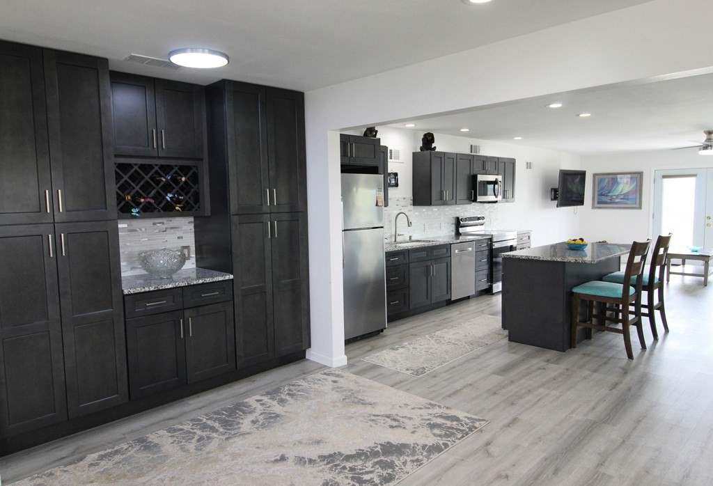 189 Sailfish Drive Rockport, TX 78382 - Photo 21 of 40 a kitchen with stainless steel appliances kitchen island granite countertop a refrigerator and a stove top oven