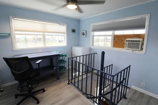 a view of a livingroom with wooden floor and windows