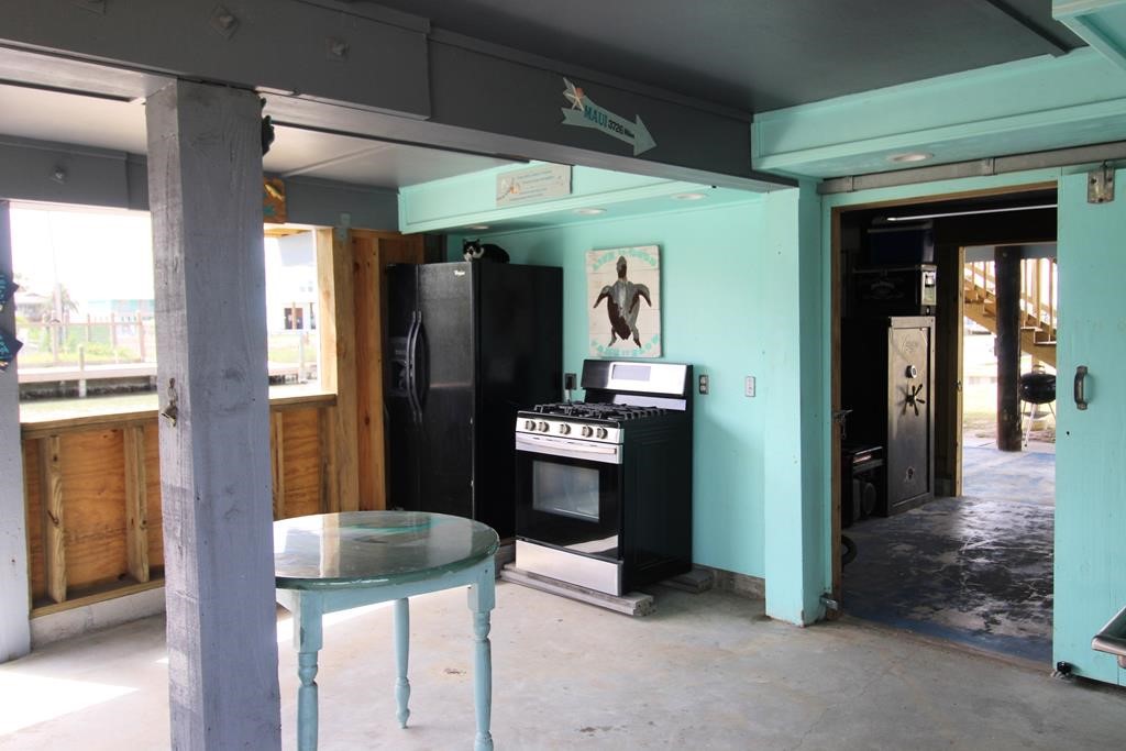 189 Sailfish Drive Rockport, TX 78382 - Photo 34 of 40 a kitchen with stainless steel appliances kitchen island granite countertop a refrigerator and a sink