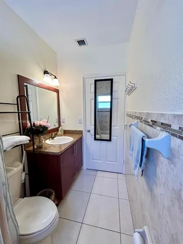 a bathroom with a sink a toilet and mirror