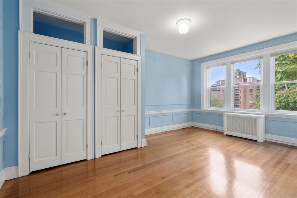 114 St Paul Street, Unit 5 Brookline, MA 02446 - Photo 11 of 22 wooden floor in an empty room with a window