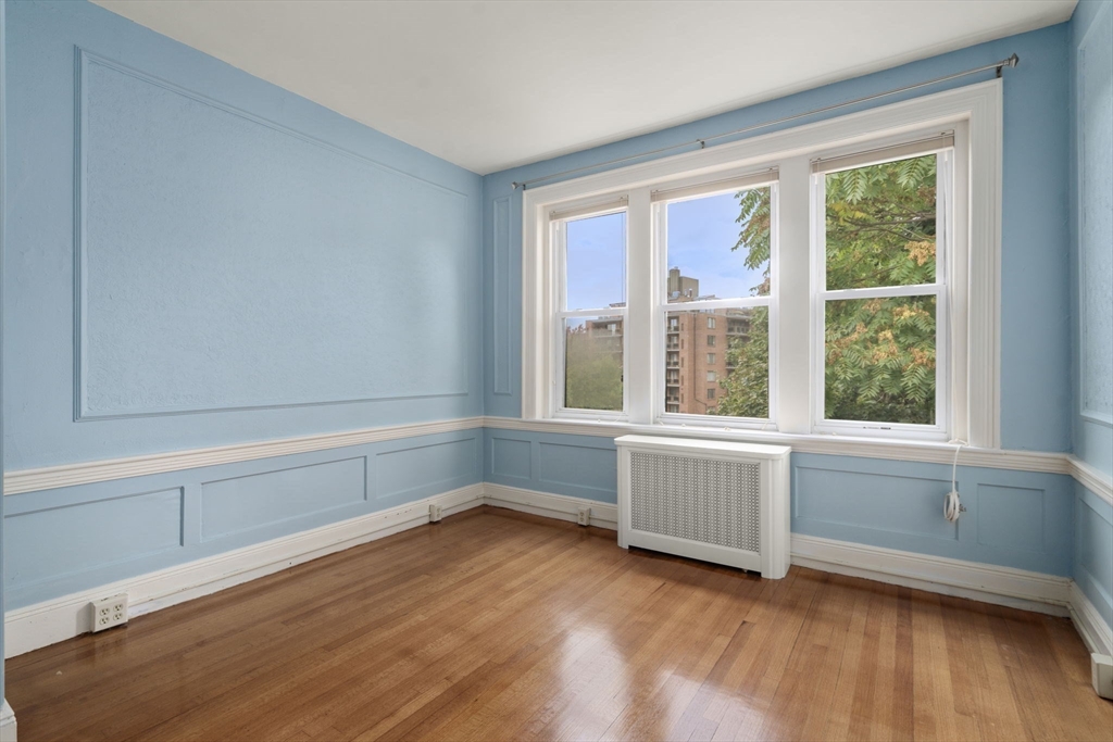 114 St Paul Street, Unit 5 Brookline, MA 02446 - Photo 12 of 22 a view of an empty room with wooden floor and a window