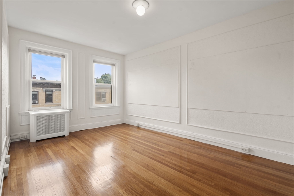 114 St Paul Street, Unit 5 Brookline, MA 02446 - Photo 14 of 22 an empty room with wooden floor and windows