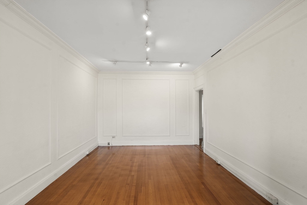 114 St Paul Street, Unit 5 Brookline, MA 02446 - Photo 7 of 22 an empty room with wooden floor and windows