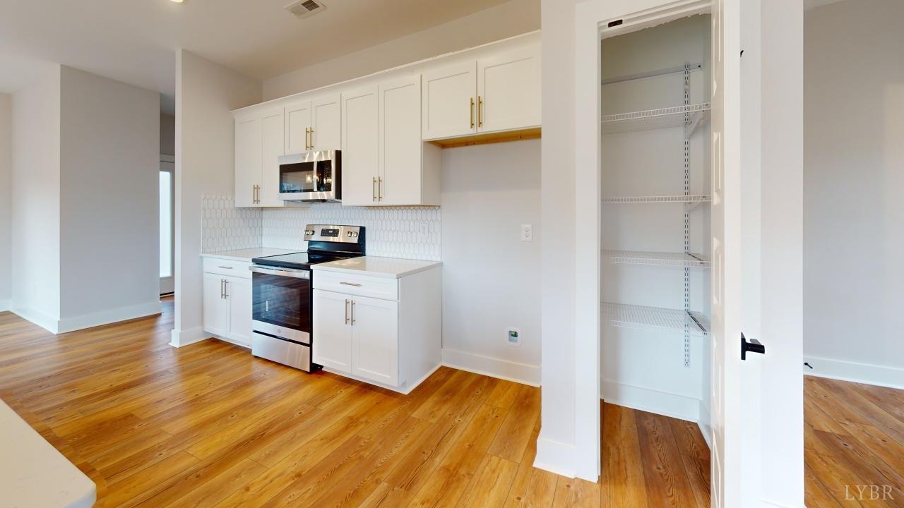 53 Shallen Road Rustburg, VA 24588 - Photo 44 of 46 a kitchen with white cabinets and wooden floor