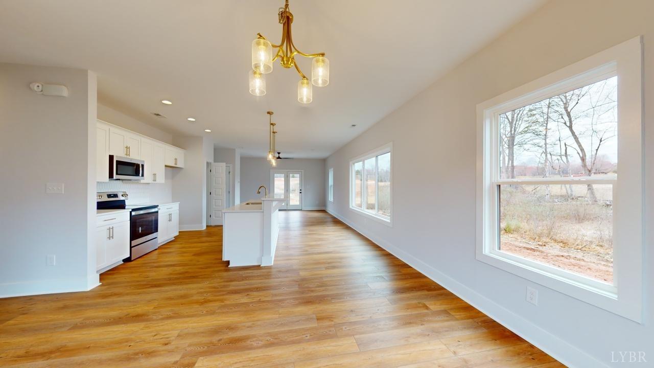 53 Shallen Road Rustburg, VA 24588 - Photo 5 of 46 a view of a kitchen and an empty room with wooden floor and windows