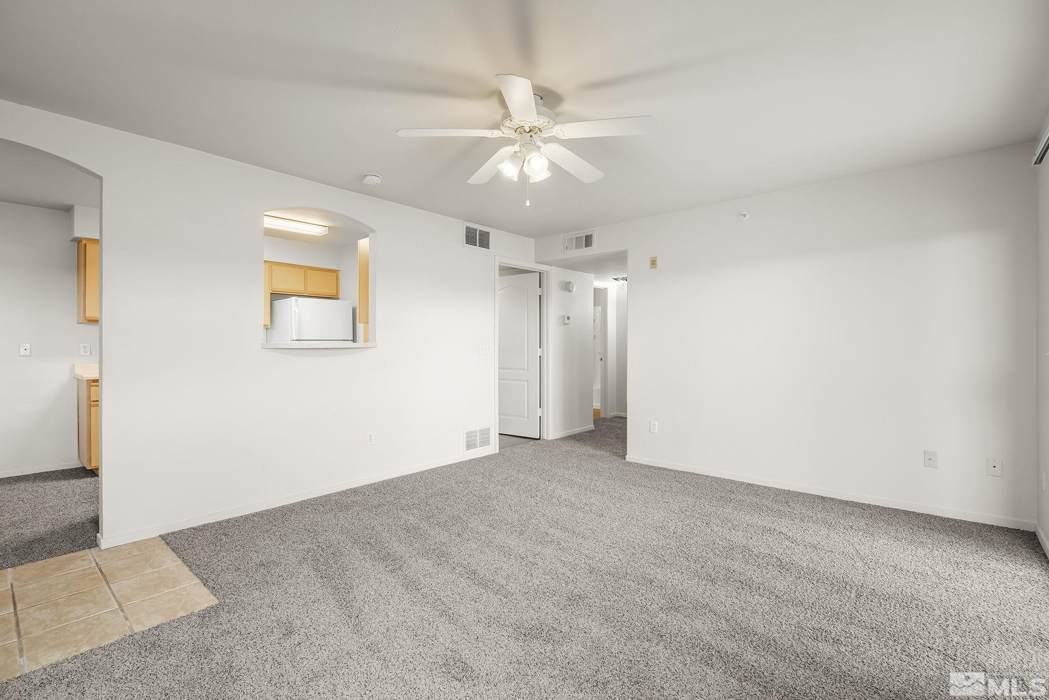 6850 Sharlands Avenue, Unit 2109 Reno, NV 89523 - Photo 4 of 16 an empty room with a ceiling fan and a window