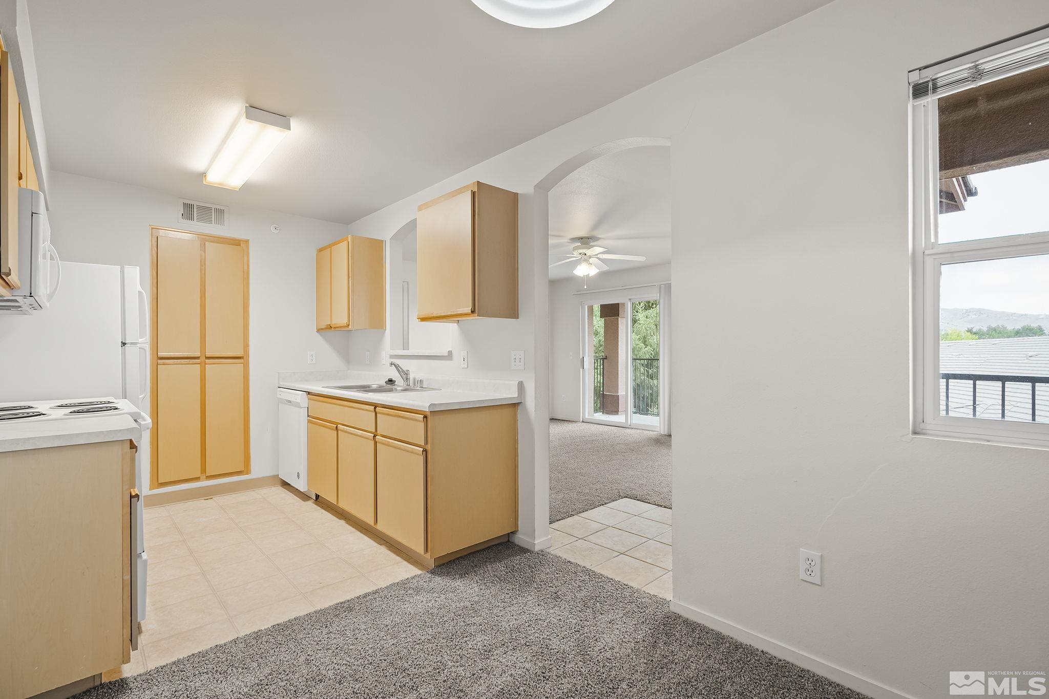 6850 Sharlands Avenue, Unit 2109 Reno, NV 89523 - Photo 7 of 16 a kitchen with granite countertop a sink cabinets stainless steel appliances and a window