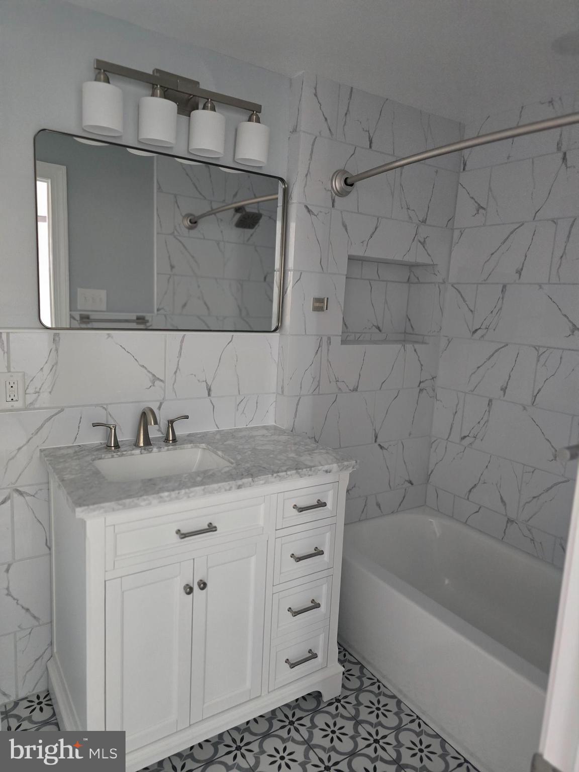 5925 Ridge Avenue, Unit 5 Philadelphia, PA 19128 - Photo 28 of 31 a bathroom with a granite countertop sink a toilet and bathtub