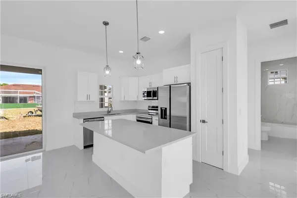 a kitchen with stainless steel appliances a stove a sink island and a refrigerator