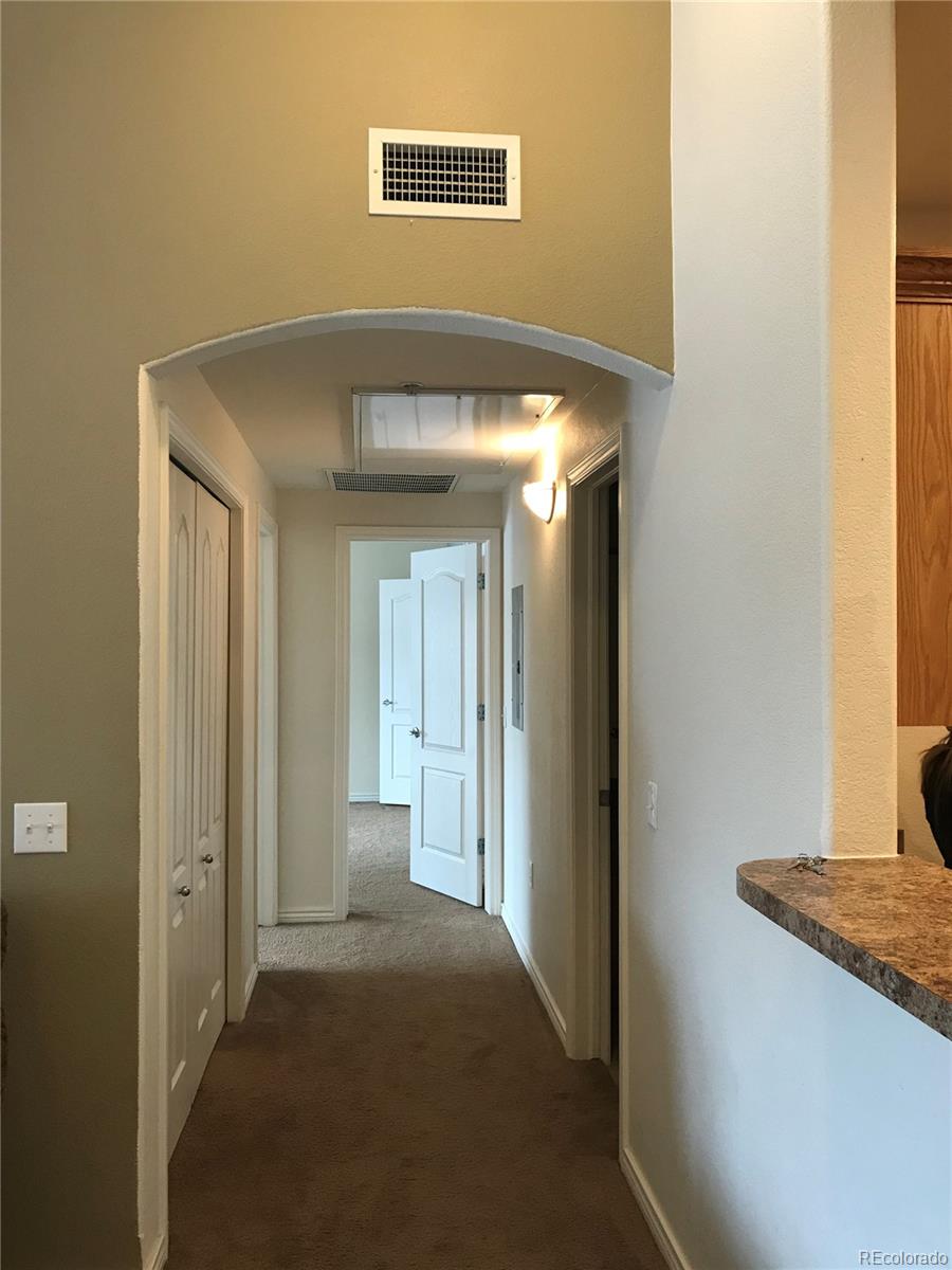 18669 Stroh Road, Unit 10204 Parker, CO 80134 - Photo 13 of 28 a view of a hallway with wooden floor and cabinet