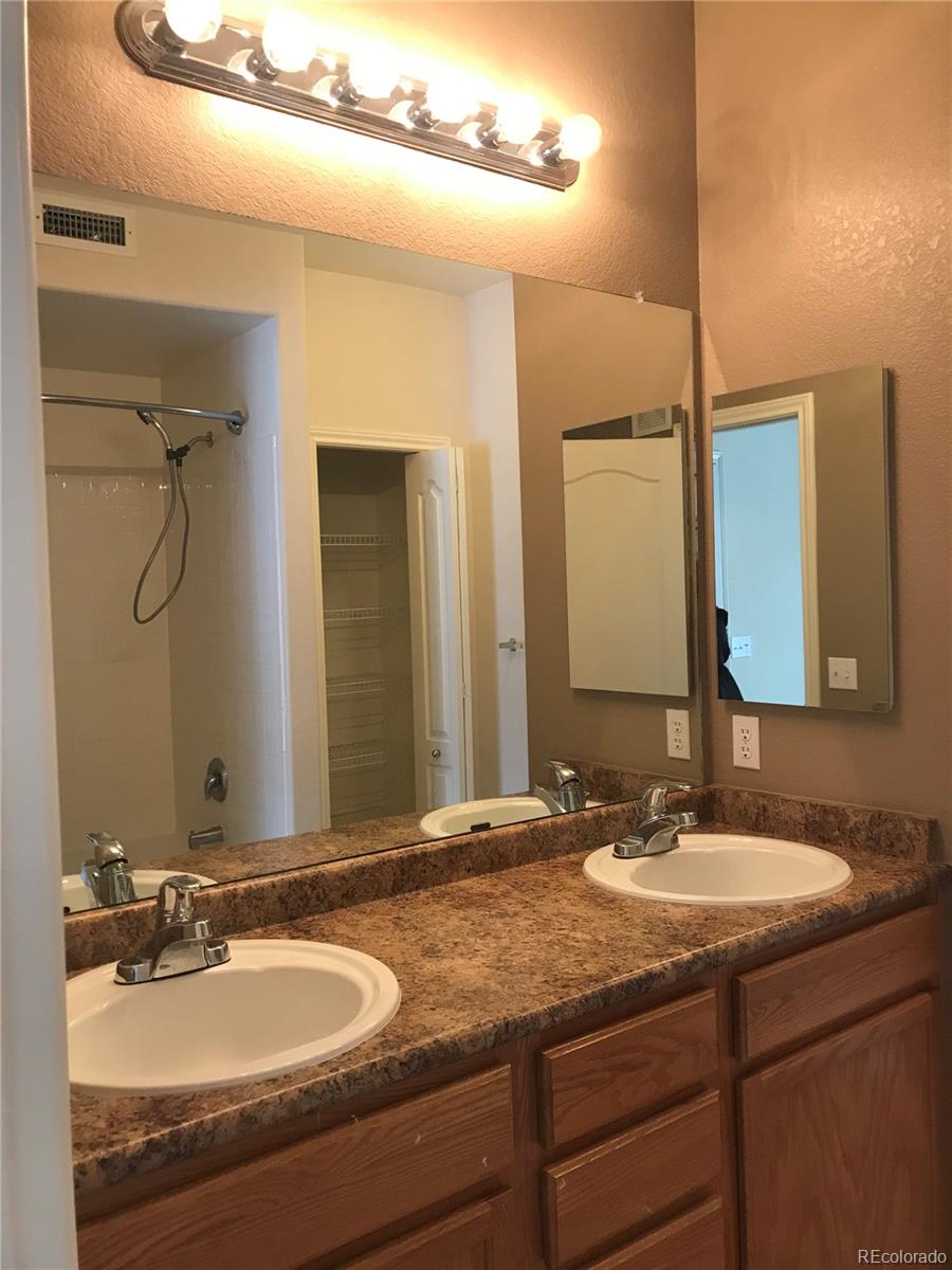 18669 Stroh Road, Unit 10204 Parker, CO 80134 - Photo 20 of 28 a bathroom with a granite countertop sink and a mirror