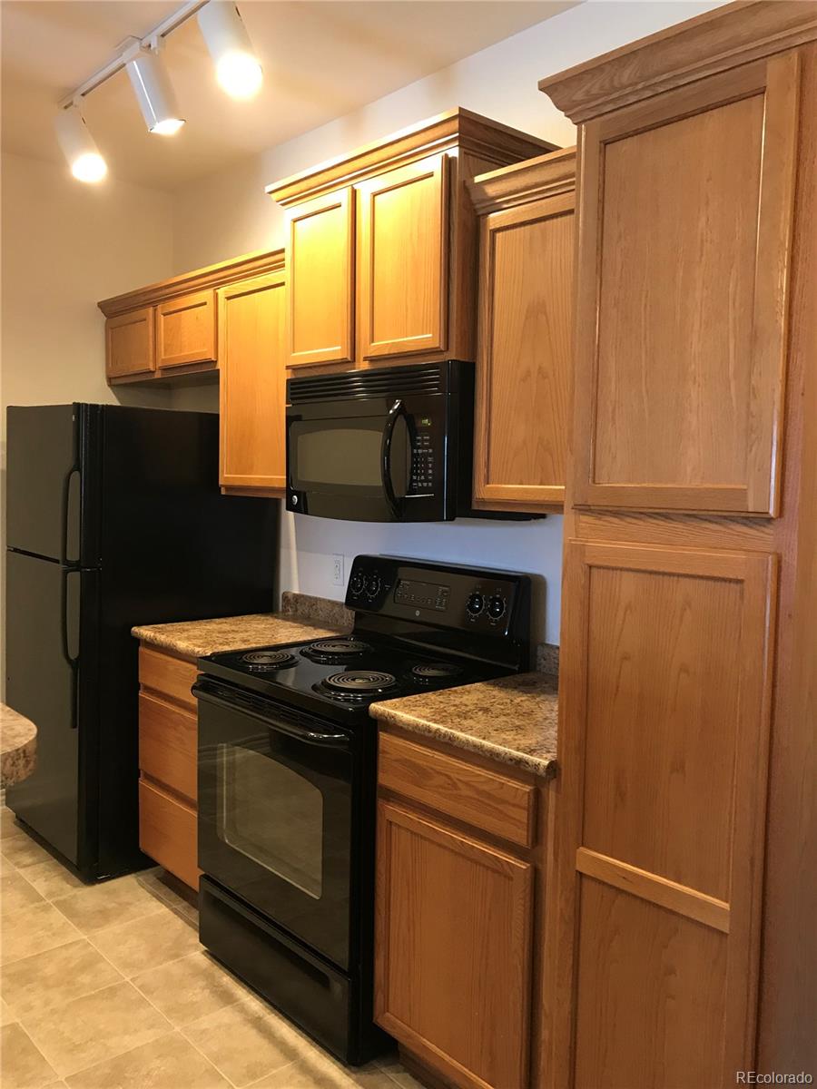 18669 Stroh Road, Unit 10204 Parker, CO 80134 - Photo 2 of 28 a kitchen with a refrigerator stove and microwave