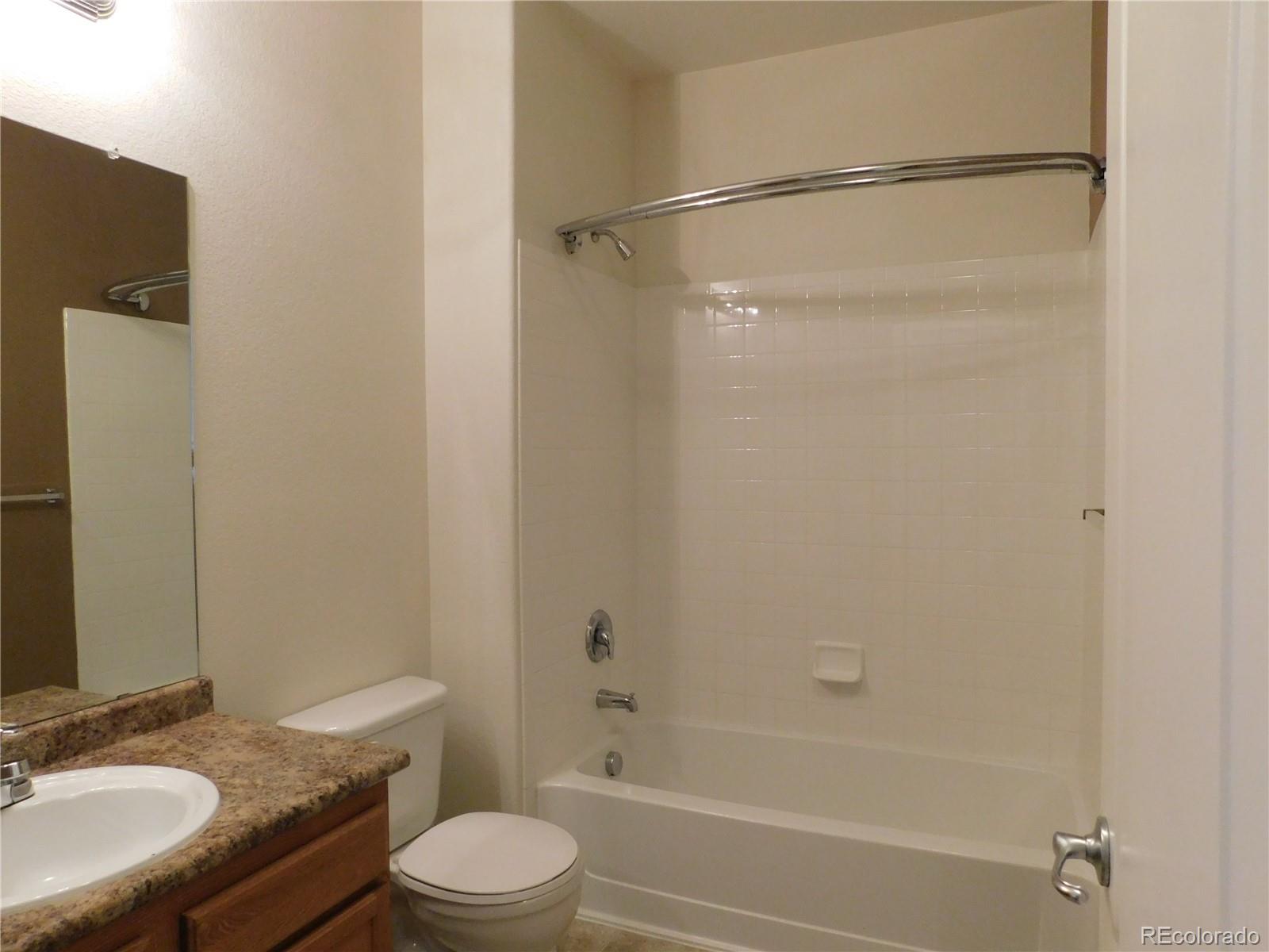 18669 Stroh Road, Unit 10204 Parker, CO 80134 - Photo 24 of 28 a bathroom with a granite countertop sink toilet and shower