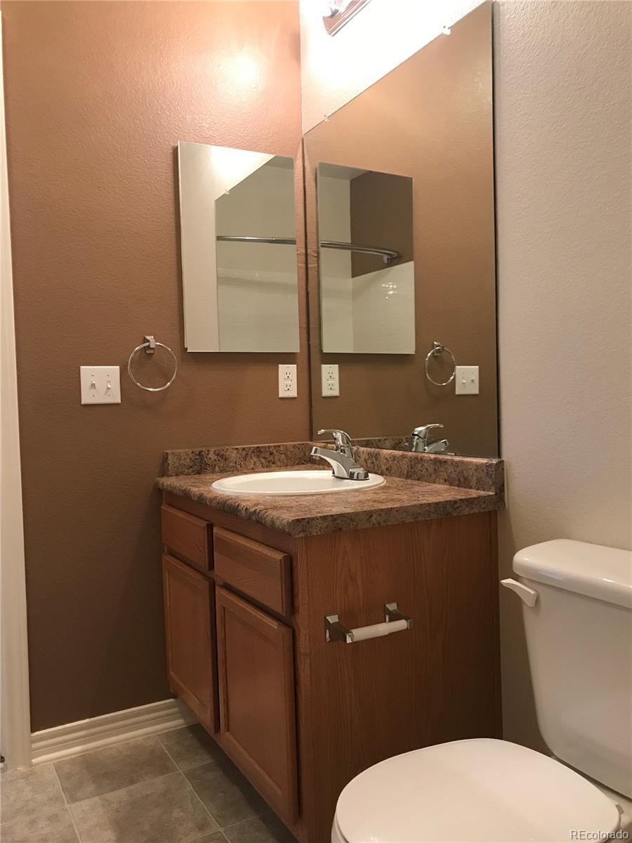 18669 Stroh Road, Unit 10204 Parker, CO 80134 - Photo 25 of 28 a bathroom with a granite countertop toilet sink and mirror