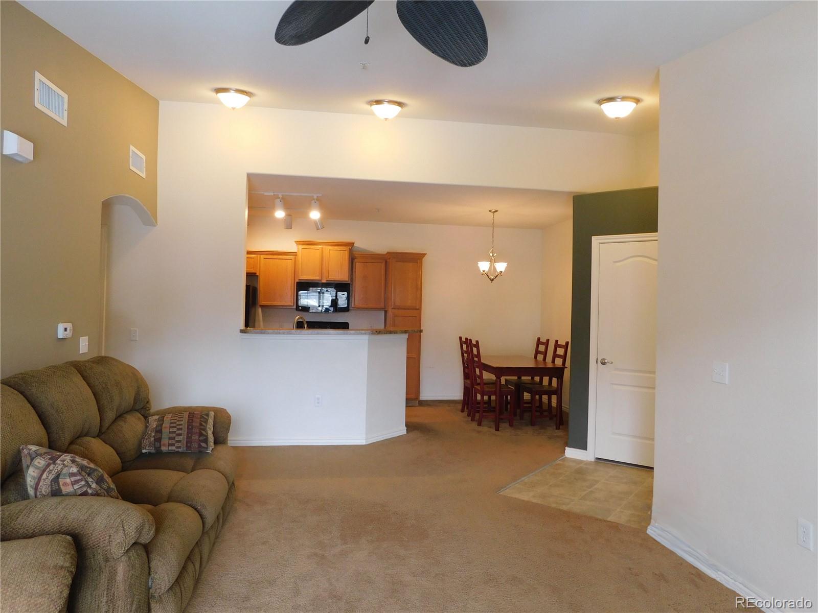 18669 Stroh Road, Unit 10204 Parker, CO 80134 - Photo 8 of 28 a living room with furniture and a chandelier