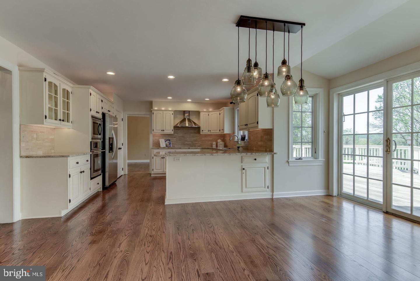 41 Old Covered Bridge Road Newtown Square, PA 19073 - Photo 24 of 58 a view of a kitchen with kitchen island wooden floors stainless steel appliances and windows