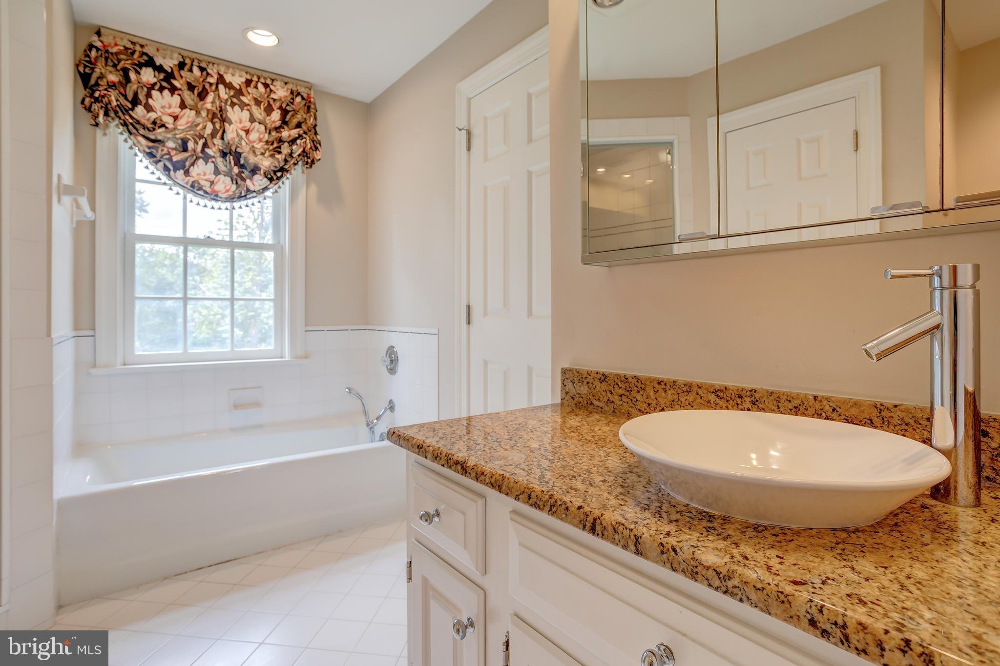 41 Old Covered Bridge Road Newtown Square, PA 19073 - Photo 38 of 58 a bathroom with a granite countertop sink and mirror bathtub