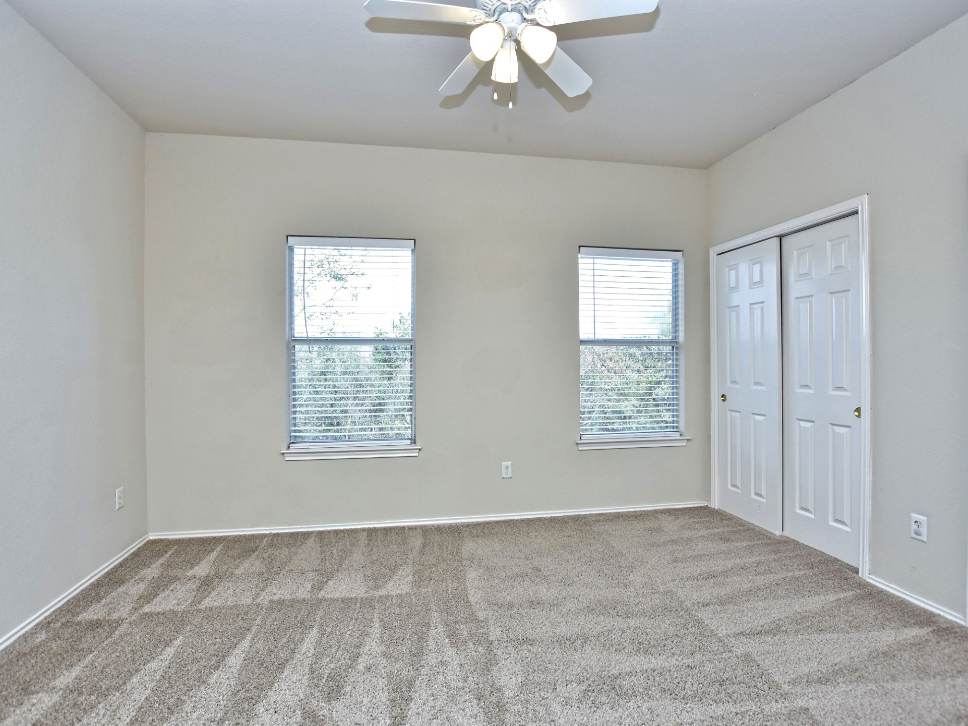 917 East 3rd Street Georgetown, TX 78626 - Photo 14 of 23 A spacious bedroom provides a blank canvas, offering ample natural light and plush carpeted flooring.