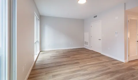 a view of an empty room with wooden floor