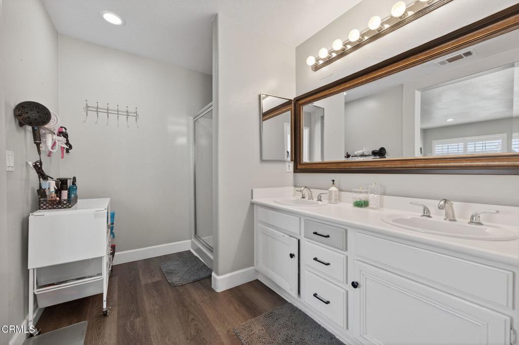 816 Noontide Way Oxnard, CA 93035 - Photo 21 of 41 a bathroom with a double vanity sink a mirror and a shower