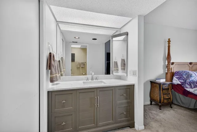 a spacious bathroom with a granite countertop sink and a mirror