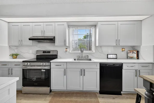 a kitchen with white cabinets and a stove top oven