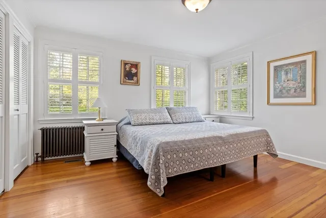 a spacious bedroom with a bed and a table with wooden floor
