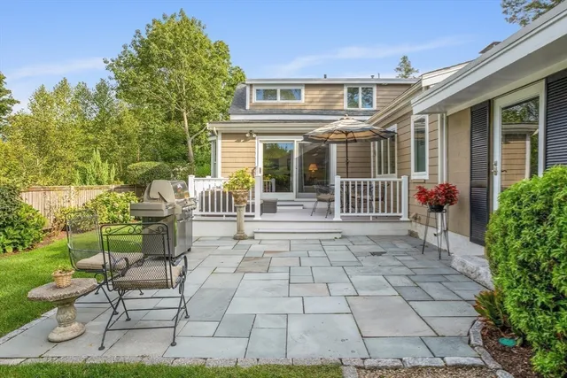 a view of a patio with table and chairs with wooden fence and plants