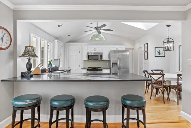 a kitchen with stainless steel appliances granite countertop a dining table and chairs in it