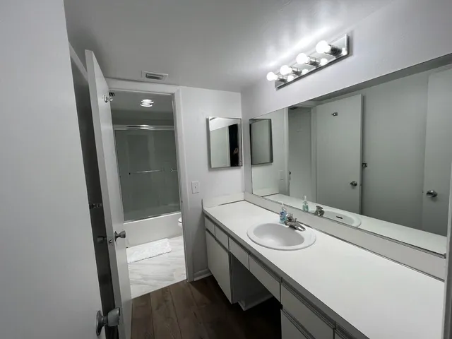 a bathroom with a sink double vanity granite tub and shower
