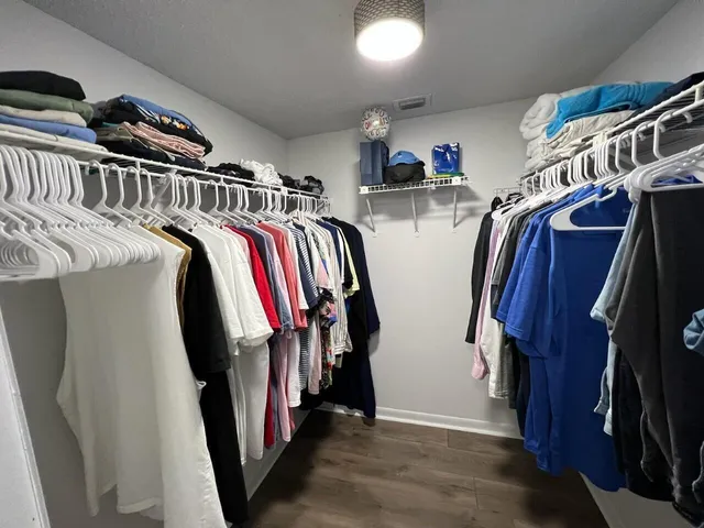 a view of walk in closet with clothes and shoes