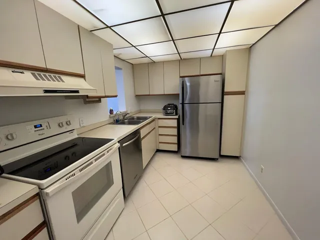 a kitchen with stainless steel appliances granite countertop a sink a stove a refrigerator and cabinets