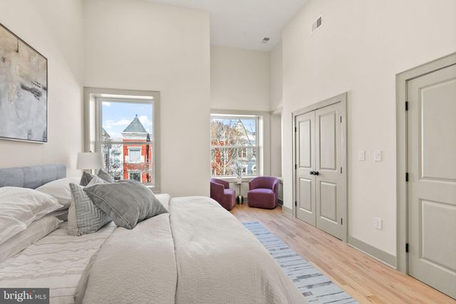 a bedroom with a large bed a couch and dresser